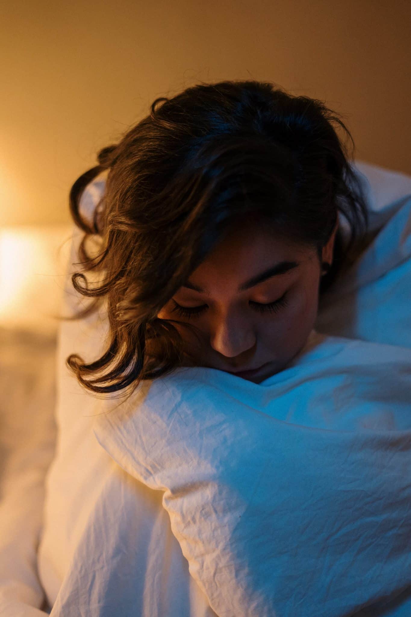 Woman on bed with white comforter