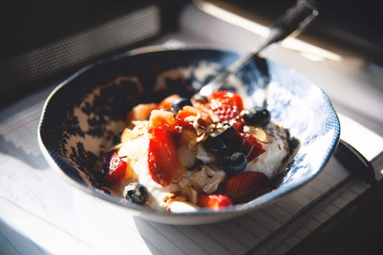 Healthy bowl of food with yogurt and strawberries and blueberries and almonds