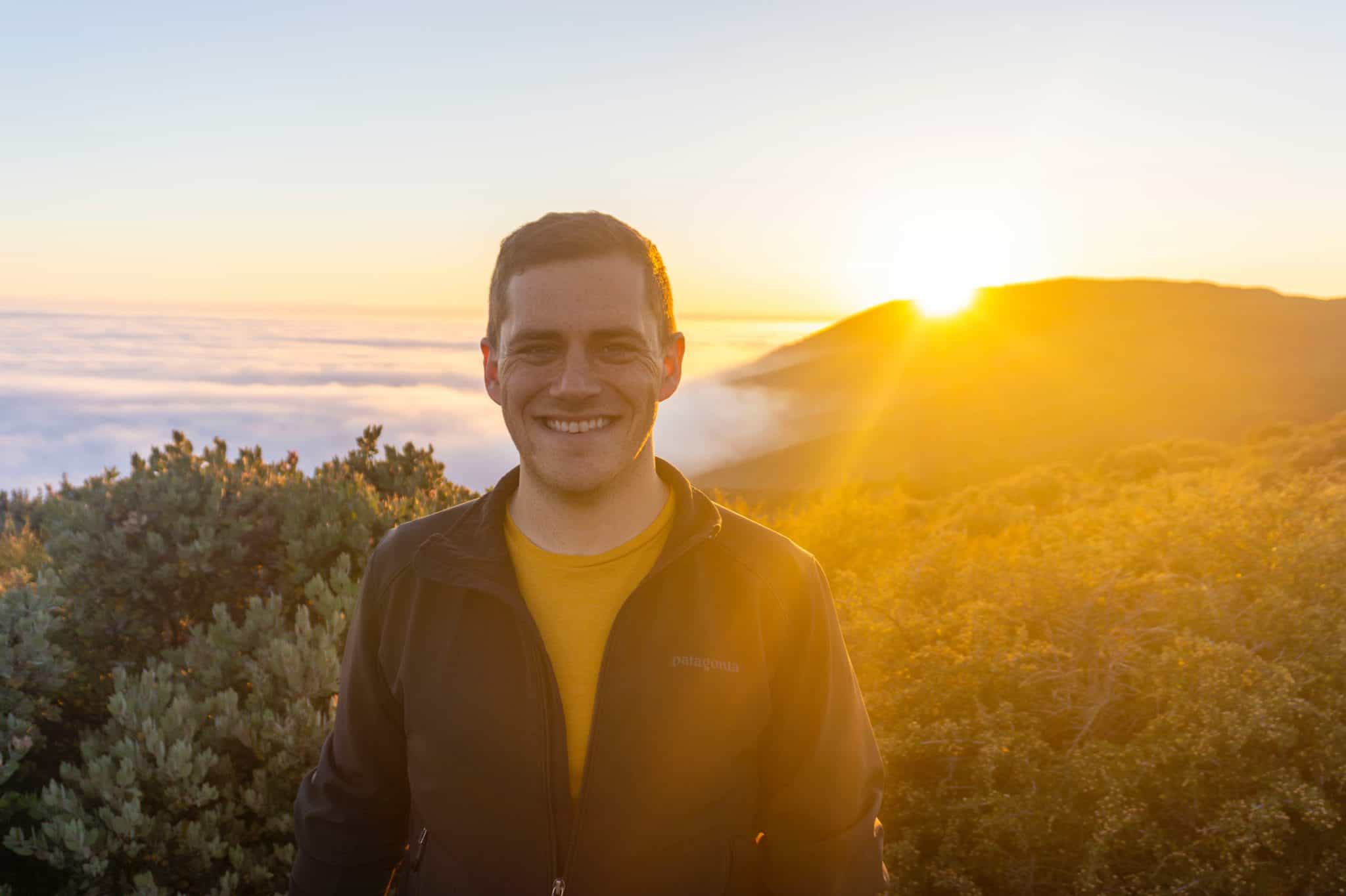 young-man-smiling-beach-sunrise