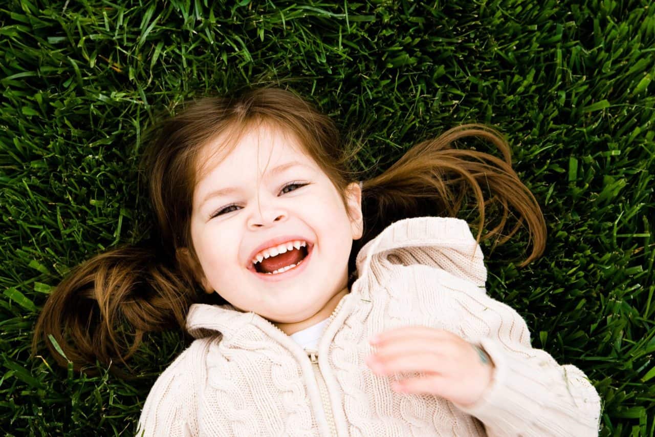 Young child in grass smiling