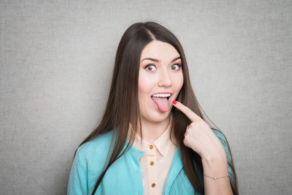 Healthy young woman sticking out tongue