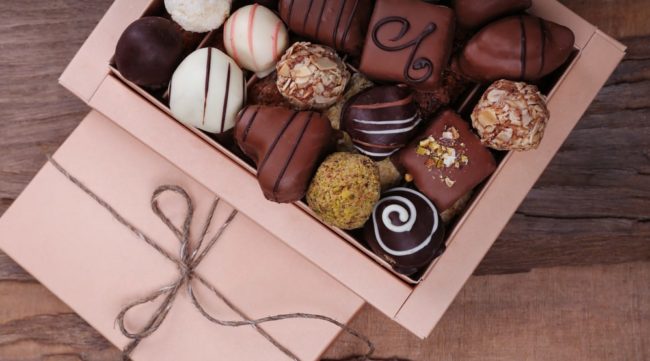 Box filled with chocolates on wooden rustic background