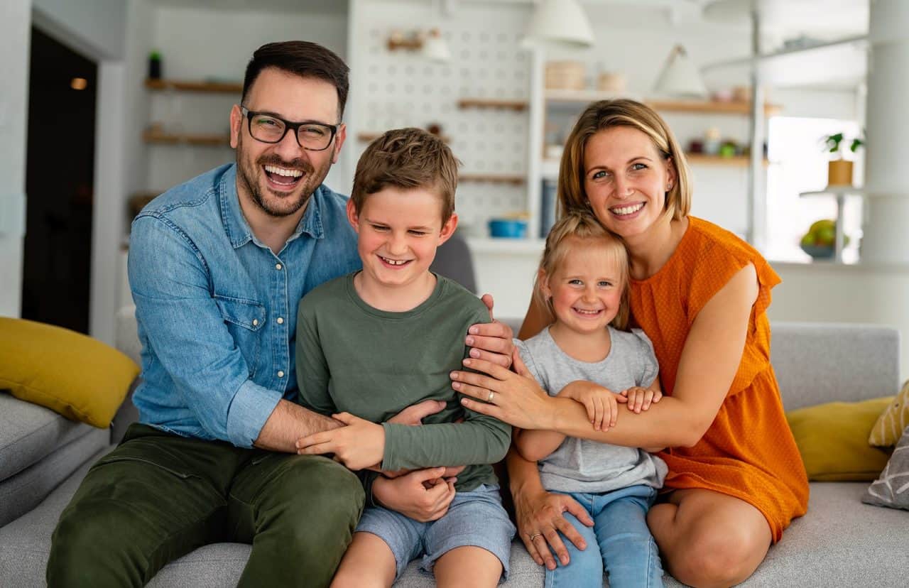 Happy family sitting on couch smiling