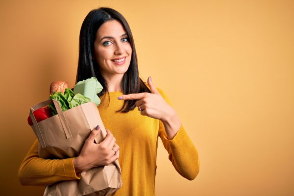 woman pointing at groceries with healthy tooth enamel