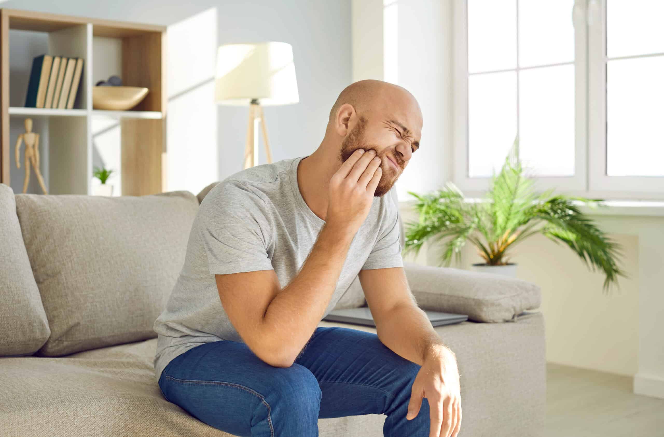 Man experiencing tooth pain and discomfort.