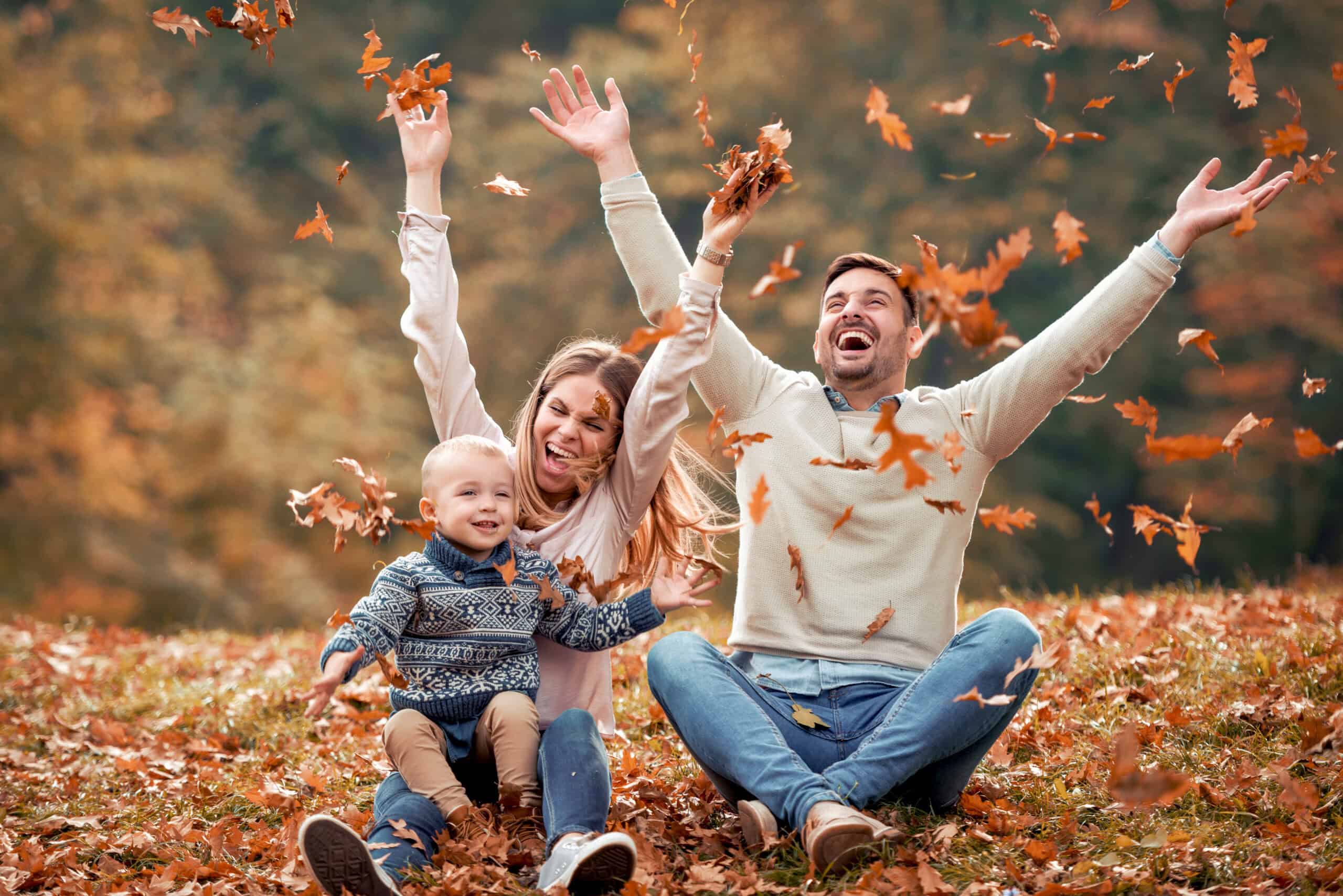 Happy family in autumn leaves.